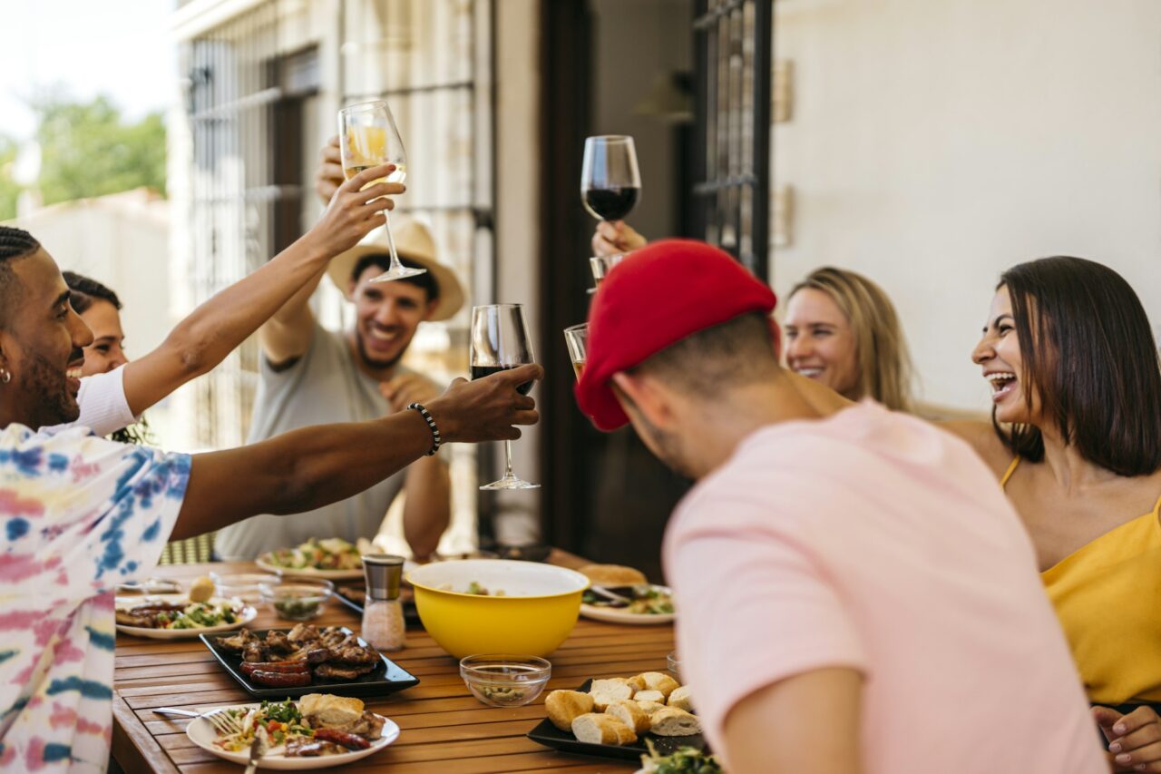 group of friends toasting while eating a barbeque