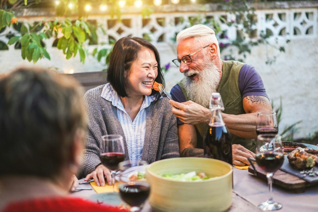 happy senior people having fun at barbecue dinner multiracial mature friends eating at bbq meal